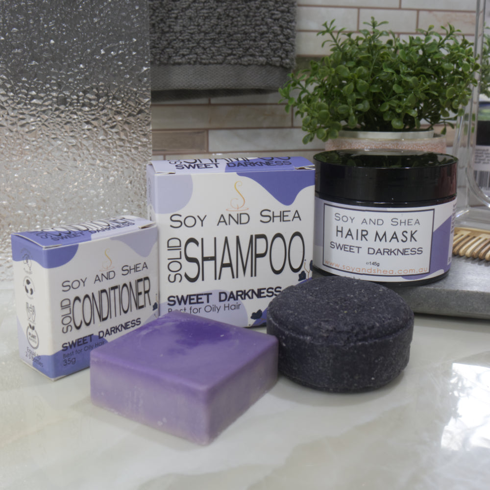 Bathroom setting with Soy and Shea hair care products including shampoo, conditioner, and hair mask. All products have purple colouring