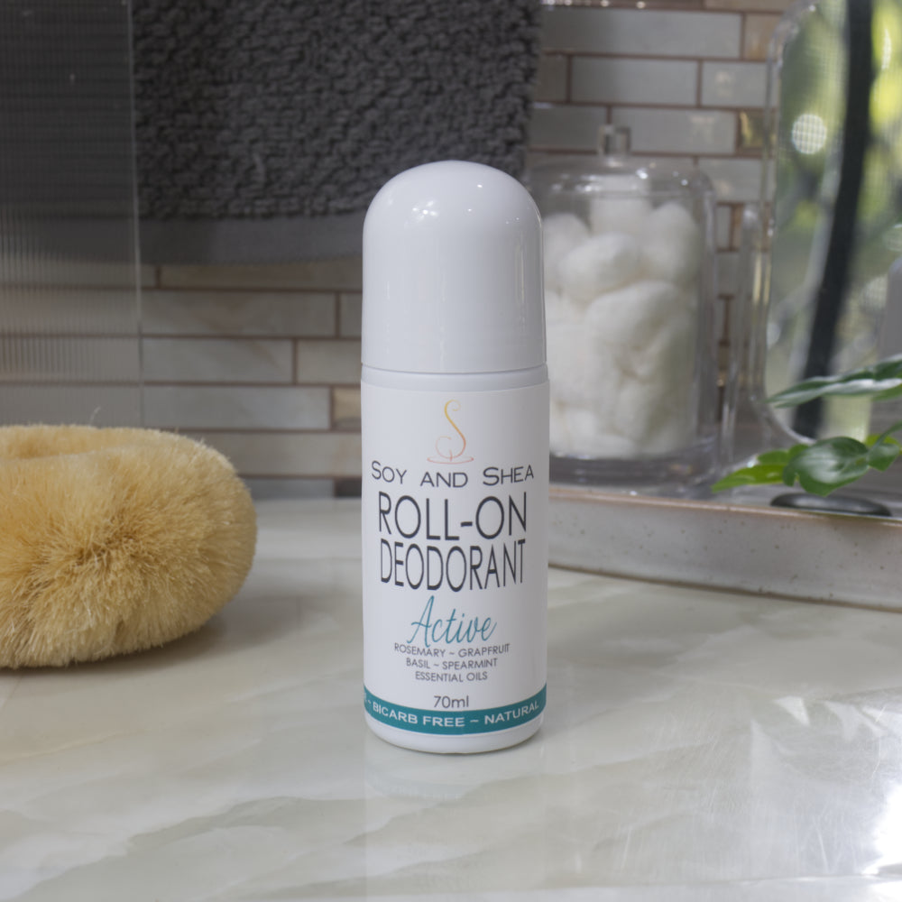 A white bottle with deocrative product label stands on a bathroom counter top.  The bottle is tall with a dome shaped cap.