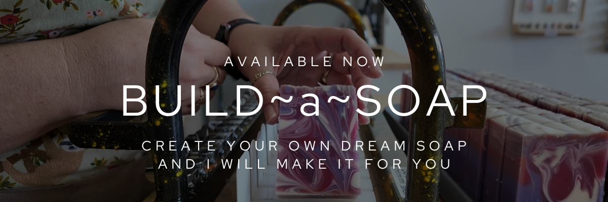 Person holding a soap bar with text overlay 'Build a Soap' and 'Create your own dream soap'.