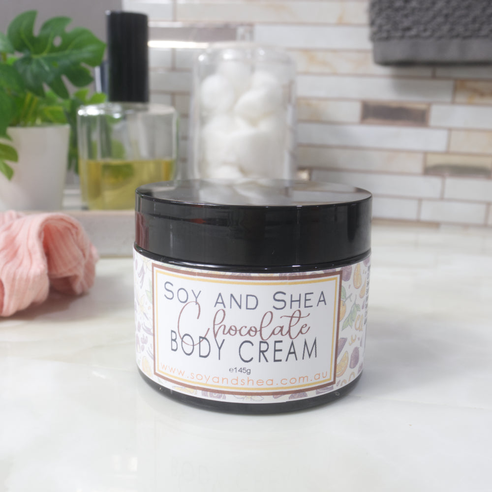 A black jar with decorative label sits on a marble countertop with a blurred bathroom background