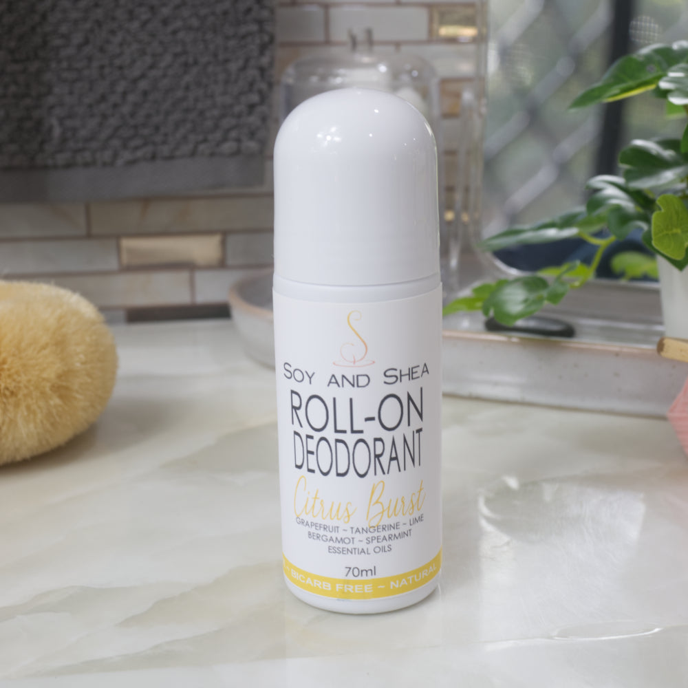 A white bottle with deocrative product label stands on a bathroom counter top.  The bottle is tall with a dome shaped cap.