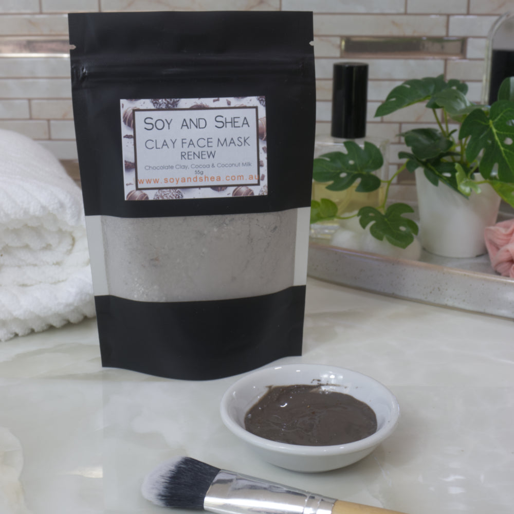 Soy and Shea Clay Face Mask packaging with a small bowl of hydrated mask and brush on a marble surface.