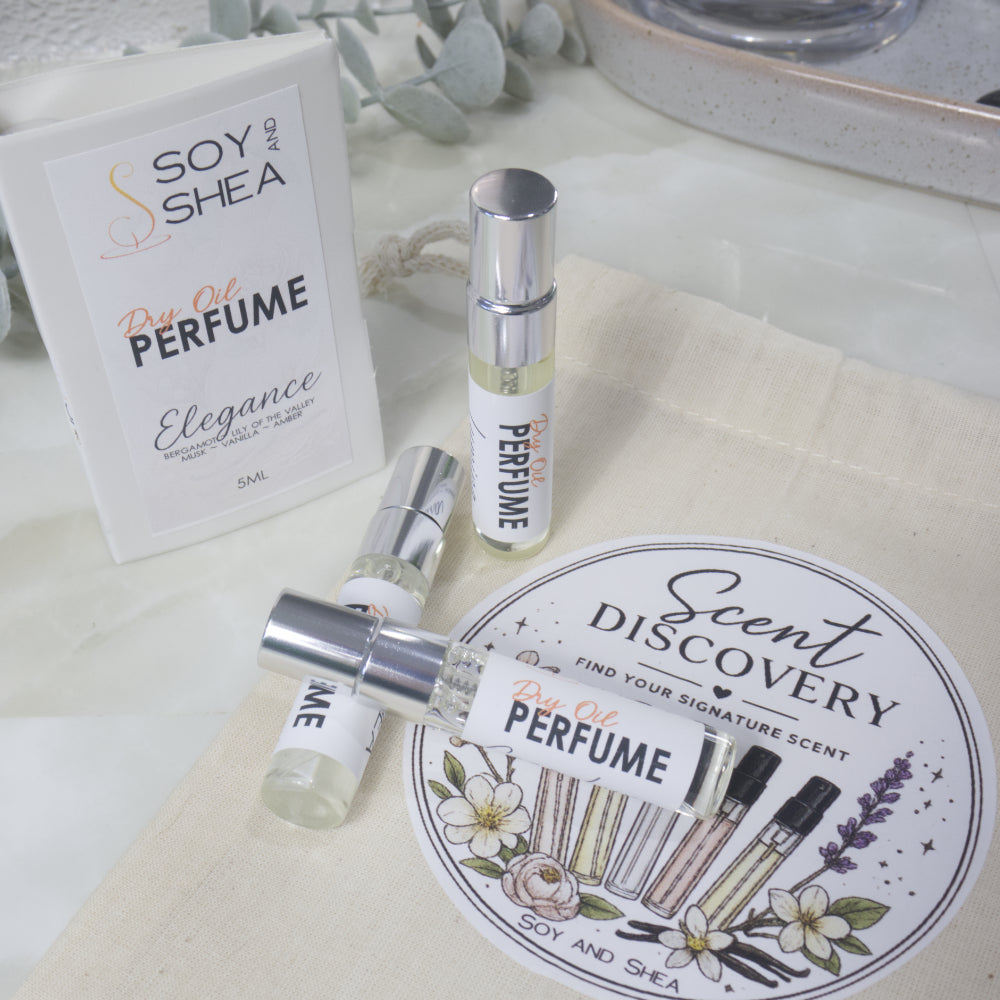A selection of small, clear glass perfume sample bottles are present lying on a calico bag labelled as Scent Discovery.  Behind is a sample card packaging for the sample bottles