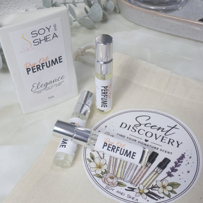 A selection of small, clear glass perfume sample bottles are present lying on a calico bag labelled as Scent Discovery.  Behind is a sample card packaging for the sample bottles
