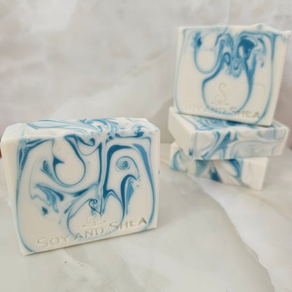 A selection of white soaps with blue swirls sit on a marble bench