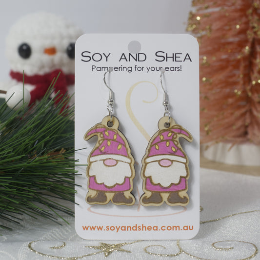 Gnome-themed earrings on a 'Soy and Shea' branded card with decorative background.  The earrings are wooden with Pink coloured gnomes