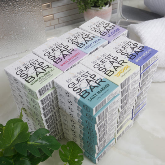 Stack of guest soap bars with colorful packaging on a bathroom counter.