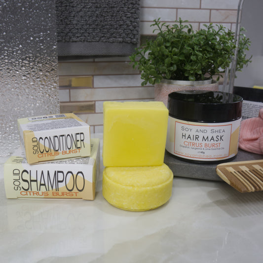 Solid shampoo, conditioner, and hair mask with packaging on a bathroom counter.  All products are in shades of yellow.