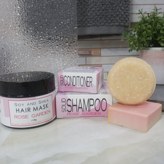 Bath products including a hair mask, conditioner and shampoo bar on a bathroom counter.  All products are in shades of pink.