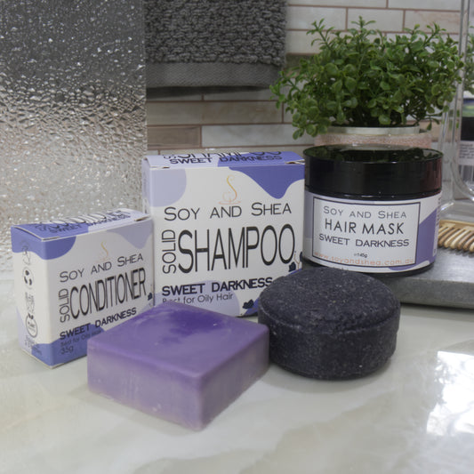 Bathroom setting with Soy and Shea hair care products including shampoo, conditioner, and hair mask.  All products have purple colouring