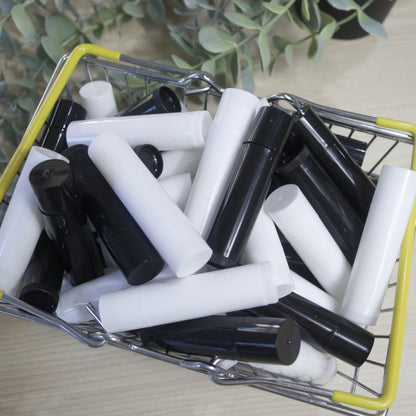 Small shopping cart filled with black and white lip balm tubes on a light surface.