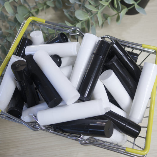 Small shopping cart filled with black and white lip balm tubes on a light surface.