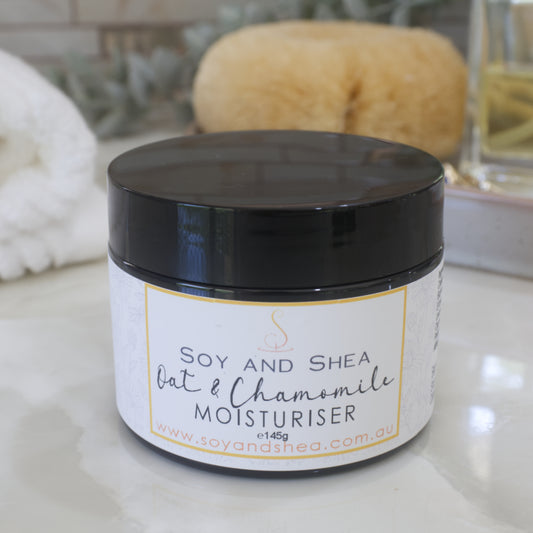 A jar with black lid and decorative product label in shades or white and yellow stands on a marble surface with a blurred background.