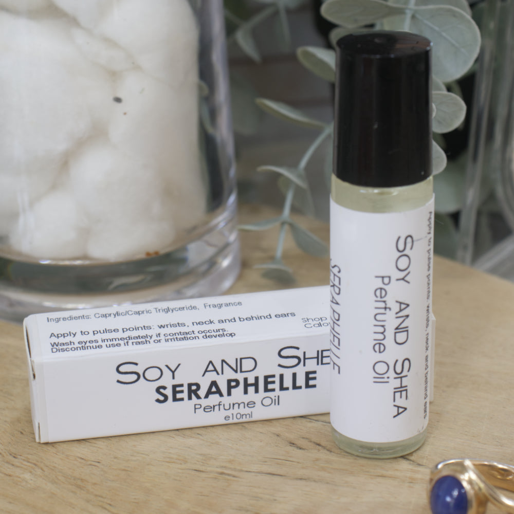 Soy and Shea Seraphelle perfume oil bottle and packaging on a wooden surface with a blurred background.