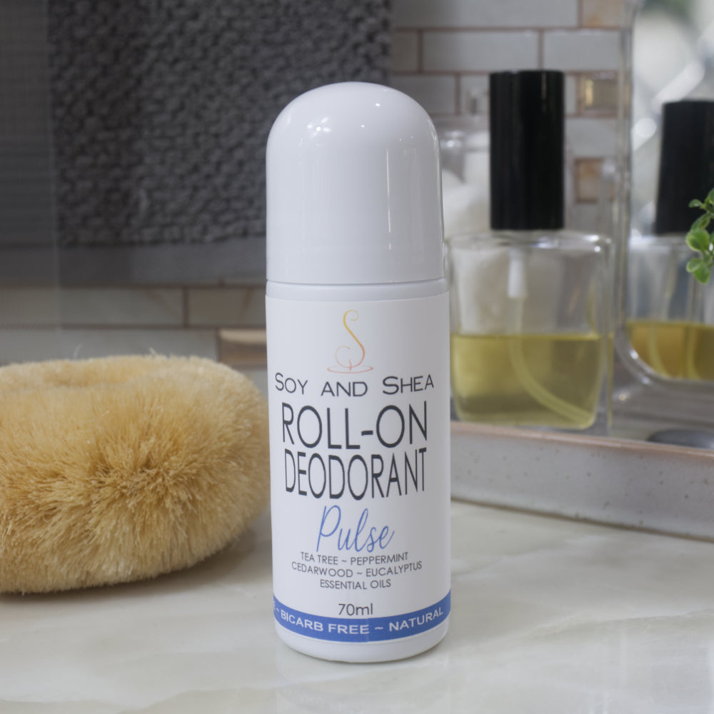 A white bottle with deocrative product label stands on a bathroom counter top.  The bottle is tall with a dome shaped cap.