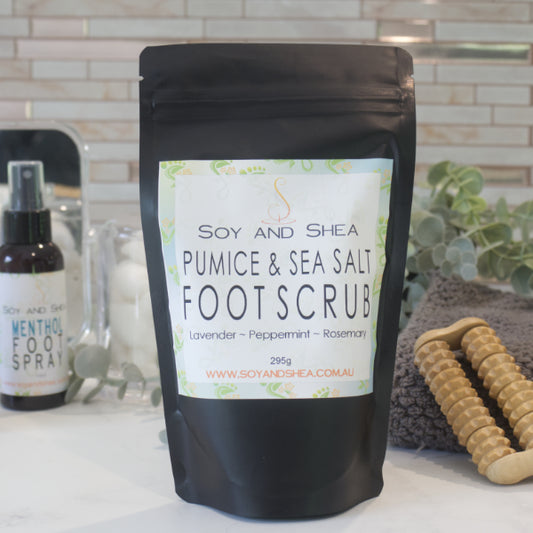 A black zip lock pouch labelled LAVENDER AND NETTLE FOOT SOAK sits on a bathroom counter along with a grey towel, wooden foot massager and bottle of Foot Spray.
