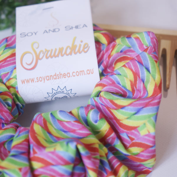A close up of the fabric design on the Rainbow Pop Scrunchie which has a rainbows swirl design in pink, blue, green, yellow and red