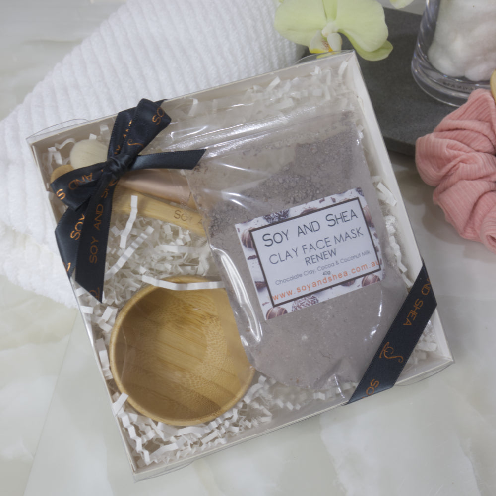 Renew Soy and Shea Clay Face Mask Gift Set with wooden scoop and decorative ribbon on a white surface.