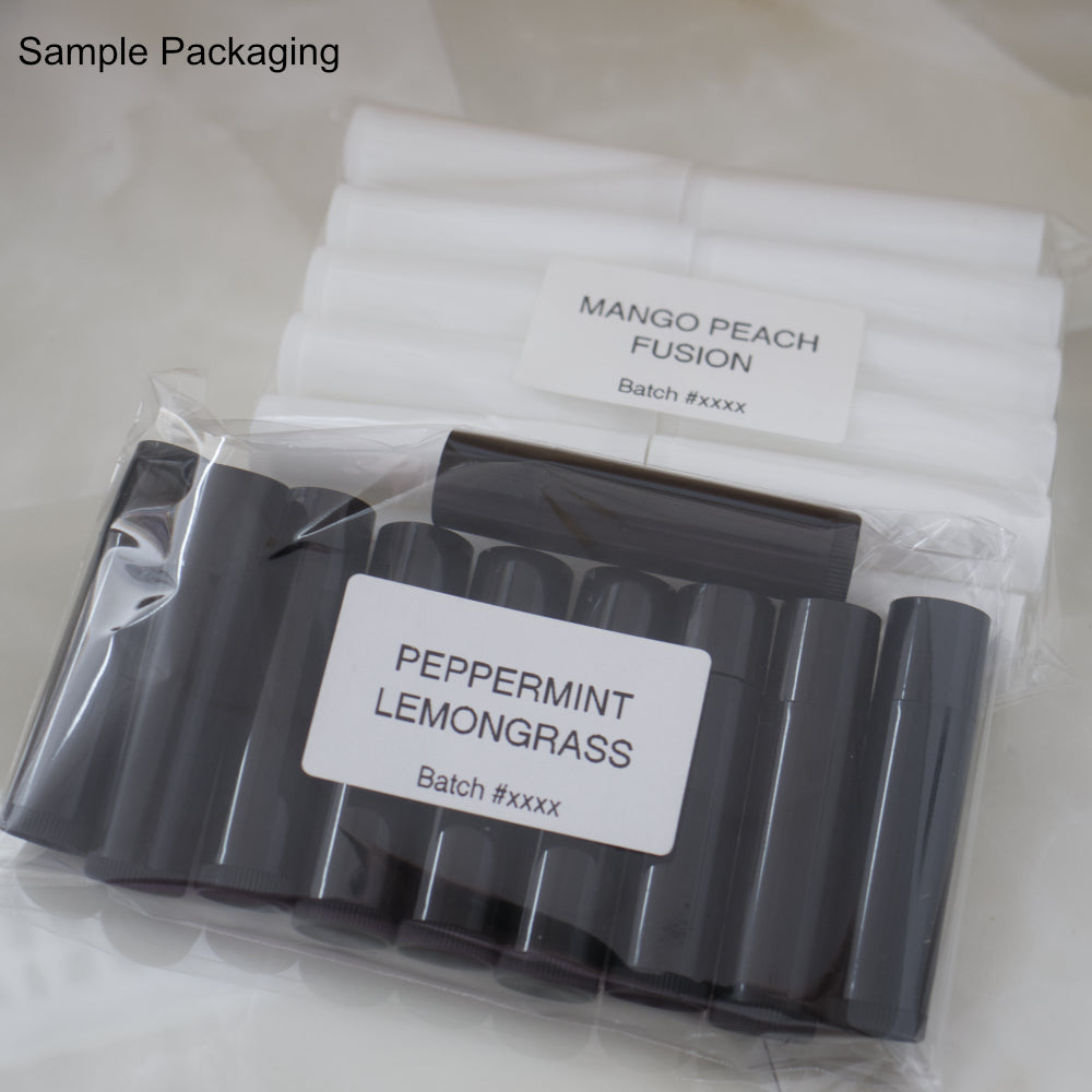 On a marble counter sits two packs containing lip balms tubes.  One pack as ten black tubes and the second has ten white tubes.  Each pack is labelled with the lip balm flavour and a batch date